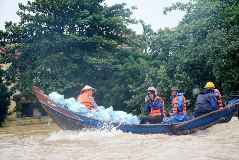 Bà con vùng không bị ngập nấu các bữa ăn, đóng thành từng suất mang vào hỗ trợ đồng bào những nơi bị ngập nặng.